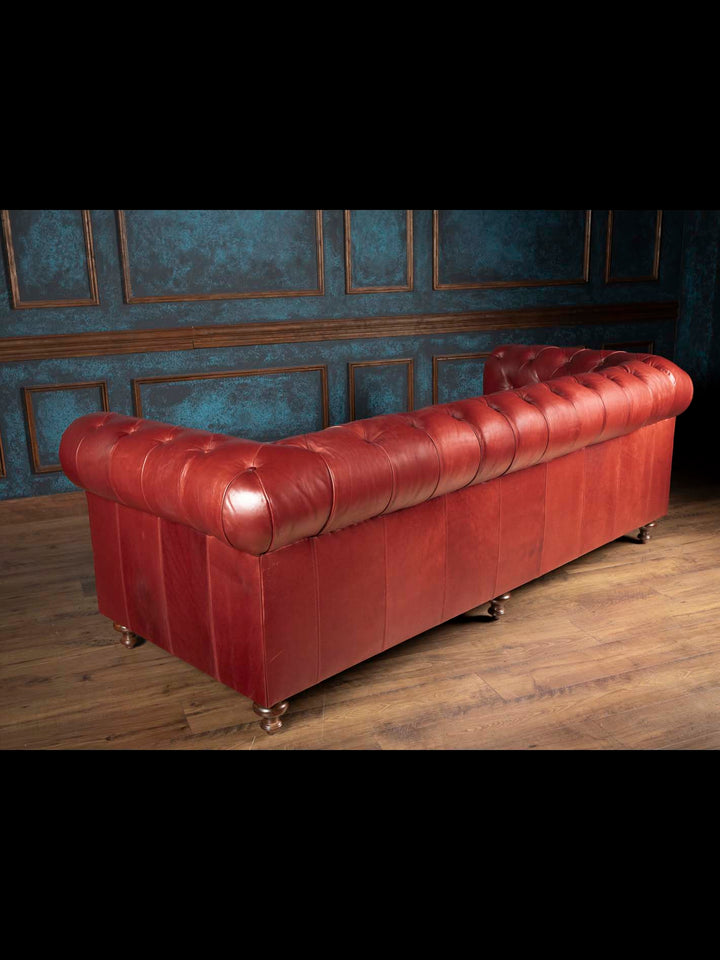 The complete backside view of the West Texas Estate leather Chesterfield sofa showcasing seamless oxblood leather paneling and solid wood legs.