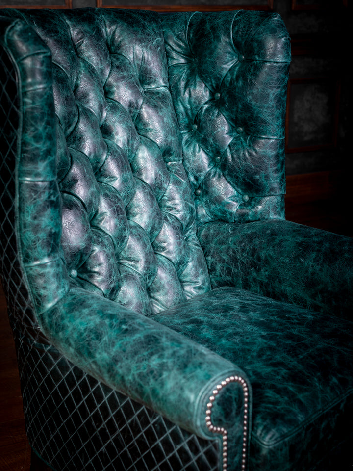 Tufted Leather Wingback Chair in distressed full grain teal leather with tufted inside back in a close-up view. 