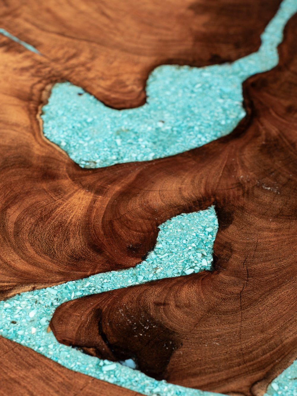 Close-up of turquoise inlay following natural openings in the mesquite coffee table’s richly grained wood top.