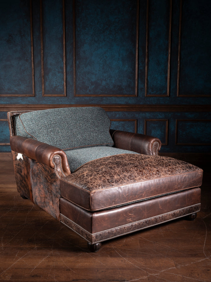 Turquoise Leather & Fabric Chaise Lounge with cowhide side panels, embossed leather cushion, and rolled arms in a western living space. 