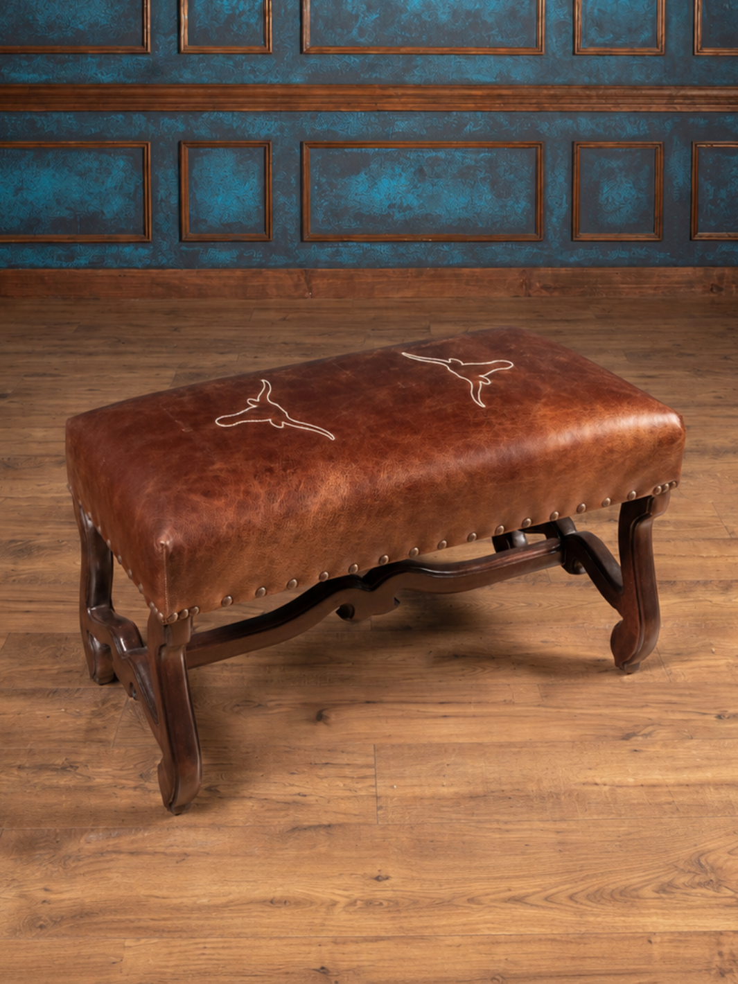 Vaquero Longhorn Leather Bench in dark rum brown full-grain buffalo leather with hand-stitched Texas longhorn embroidery, in a western style home interior.