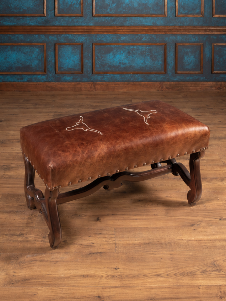 Vaquero Longhorn Leather Bench in dark rum brown full-grain buffalo leather with hand-stitched Texas longhorn embroidery, in a western style home interior.