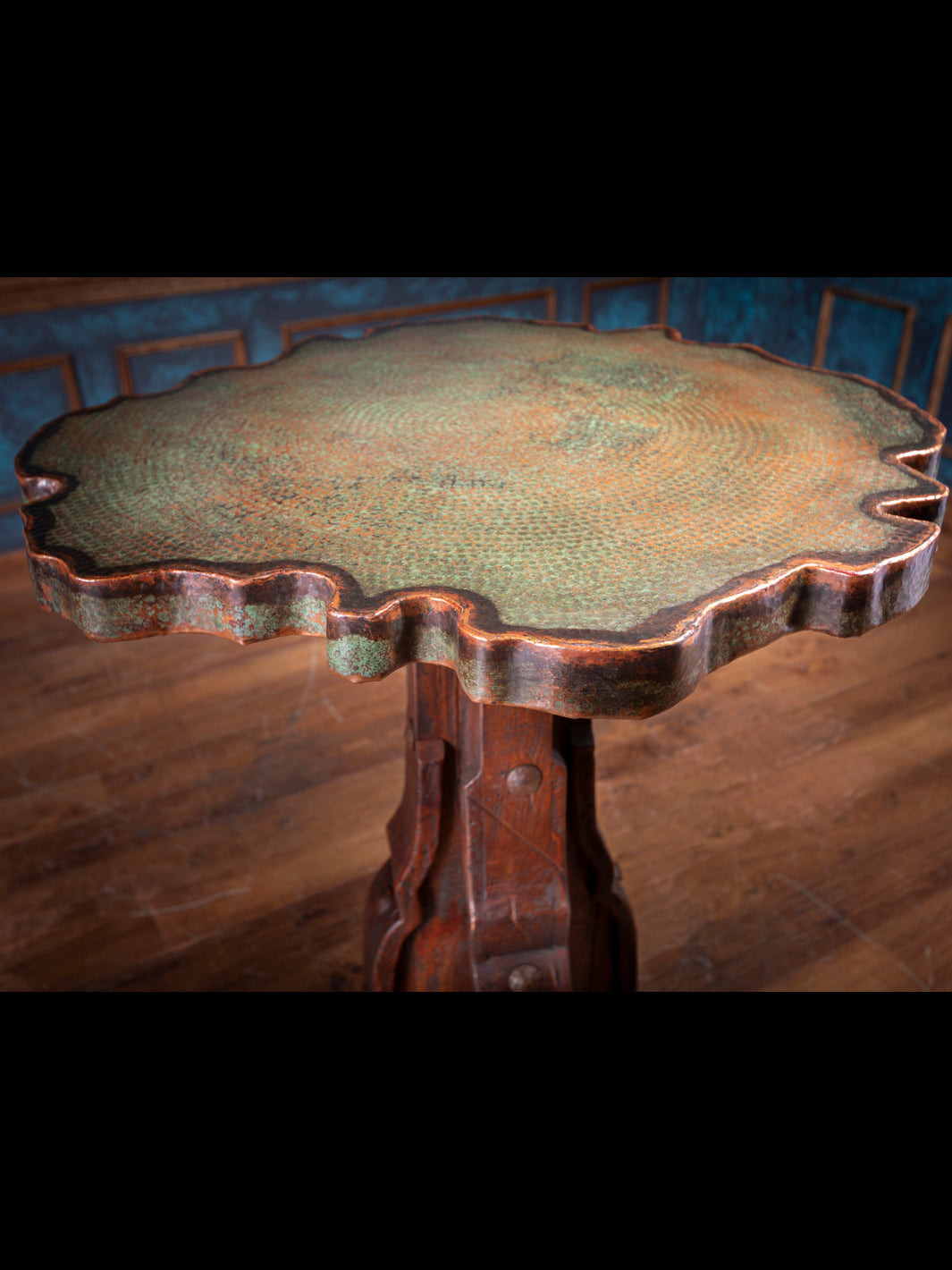 Scalloped live edge of verdigris copper tabletop showing patina and artisan craftsmanship.