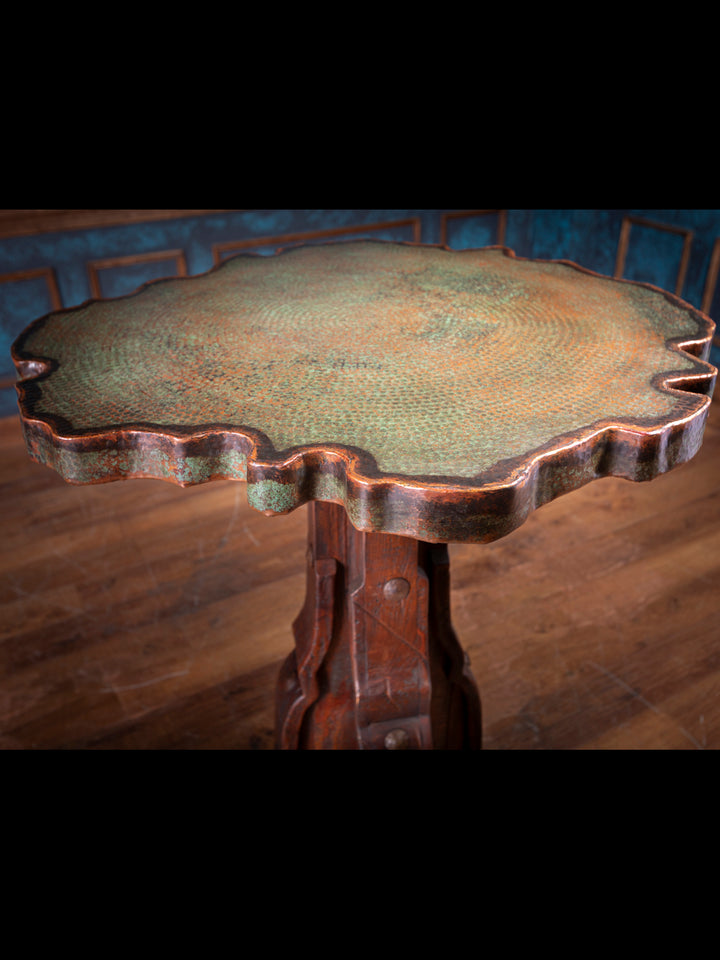 Scalloped live edge of verdigris copper tabletop showing patina and artisan craftsmanship.