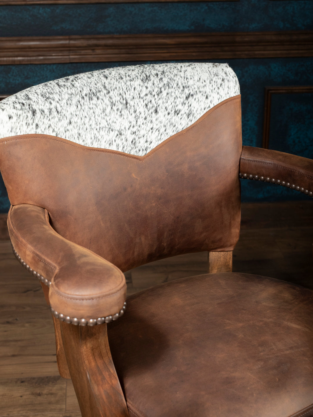 Western Heritage Leather Barstool in full aniline brown leather with cowhide accents and brass nailheads in a close-up view.