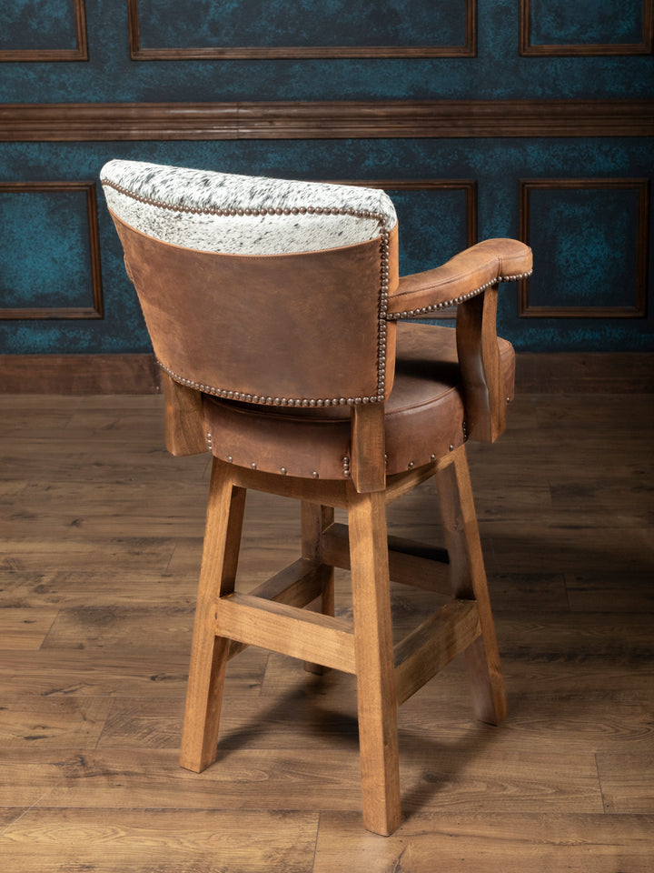 Western Heritage Leather Bar Stool with brown distressed leather and hair on hide accents with hardwood frame in a western living room.