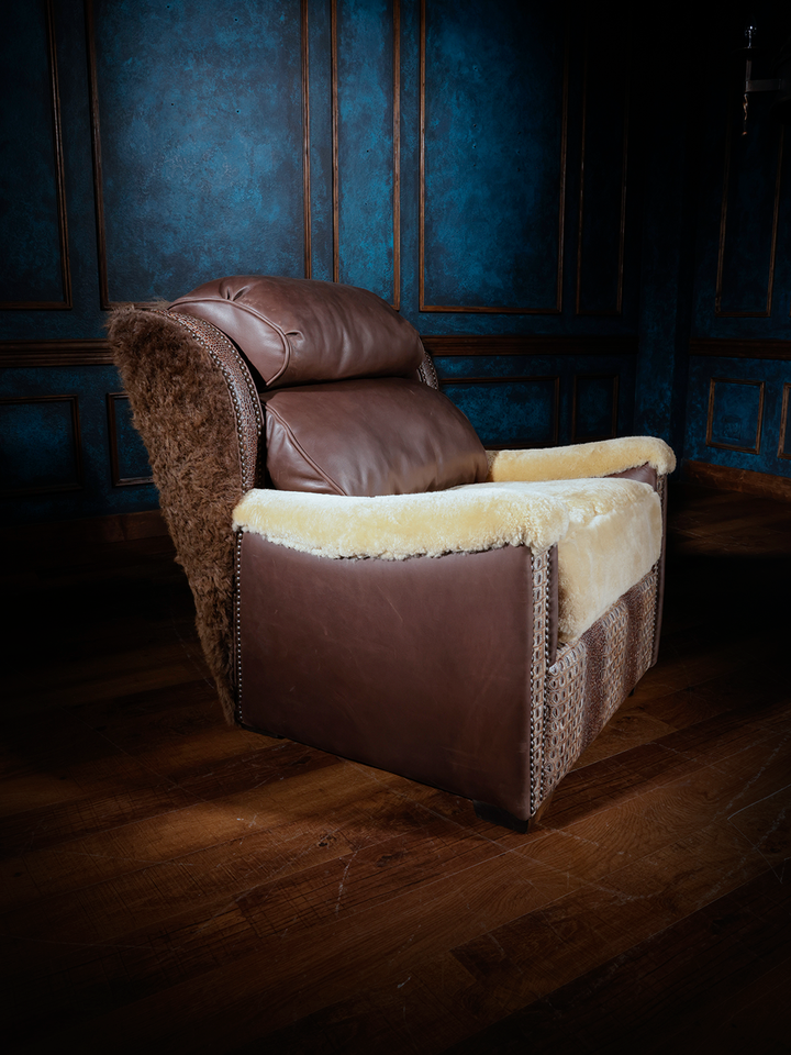 A Western-style leather accent chair featuring a back and arms covered in shearling, with a smooth leather seat cushion and leather accents on the sides.