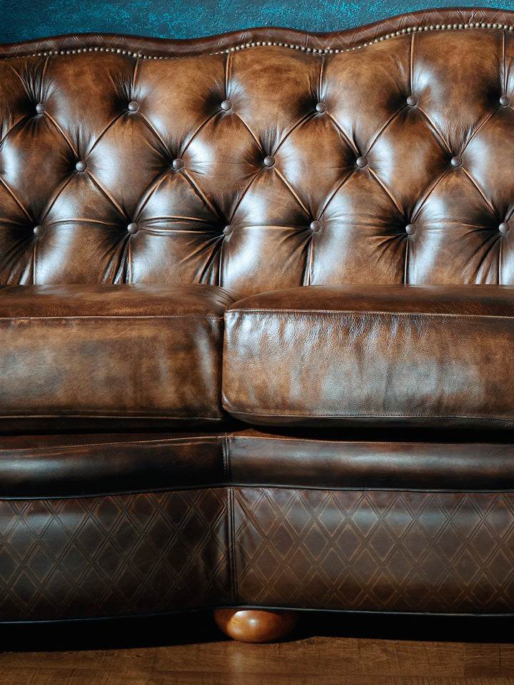 Close up shot of tufted brown leather sofa