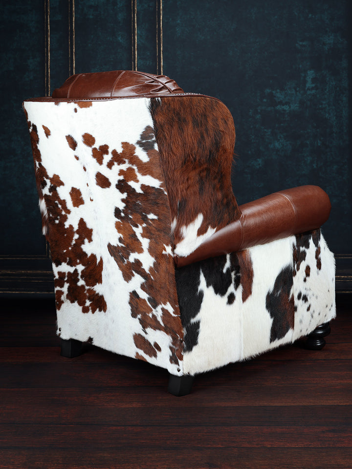 Bushwacker Leather and Cowhide Recliner with tri-colored cowhide on the outside back in a studio setting.