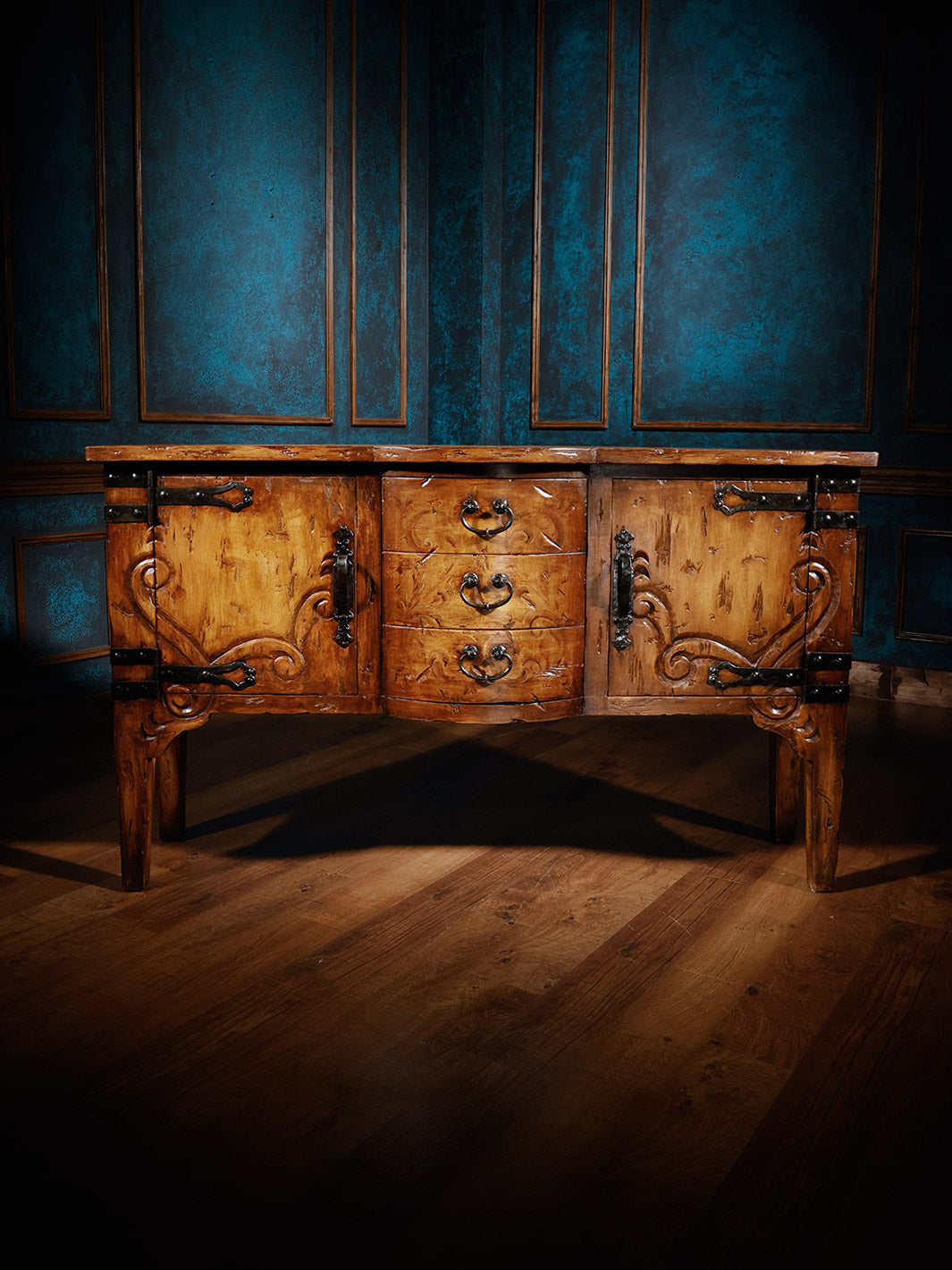 A brown wooden console table with intricate wood grain patterns and metal accents on a blue background.