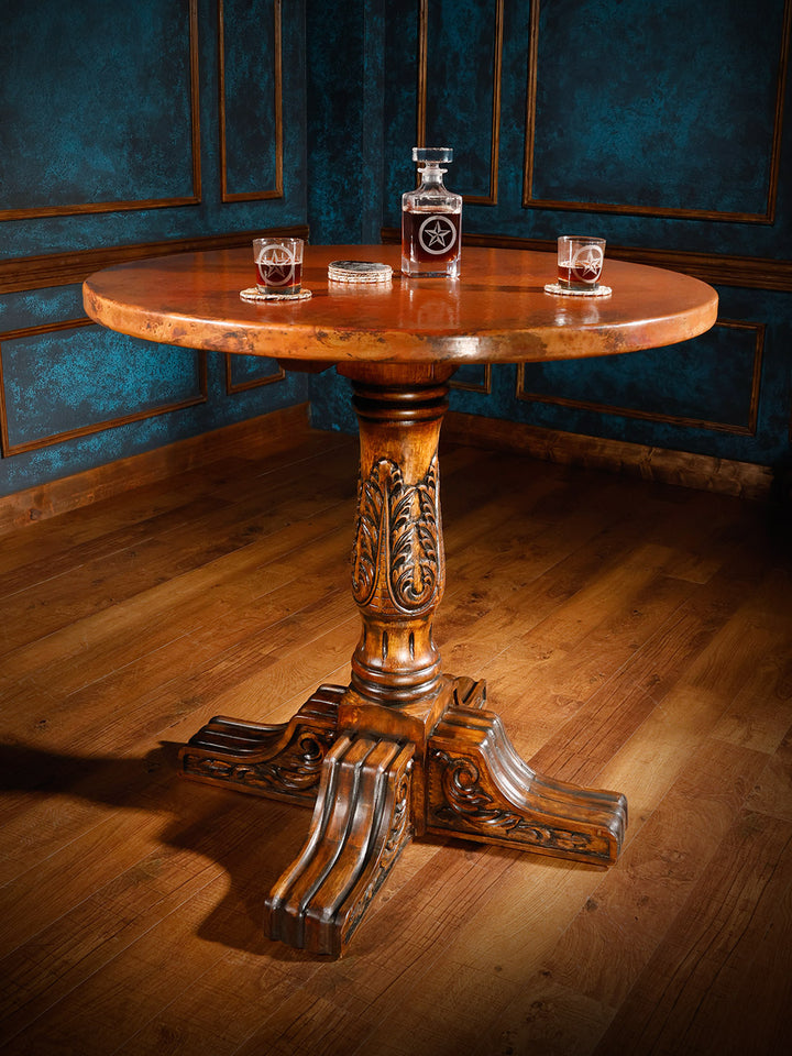 Copper top pub table with a round patina copper top and hand-carved base styled in a Western bar space.