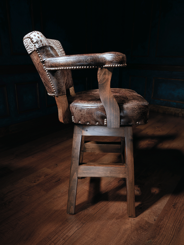 Kryptonite Cowboy Western Bar Stool in brown leather and brass nailhead detailing in a moody rustic space.
