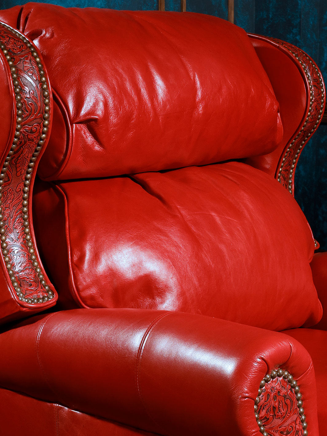 Red Rider Western Leather Recliner in Ruby Red leather and Cowboy Tool embossed inlays with silver nailheads in a close-up view.