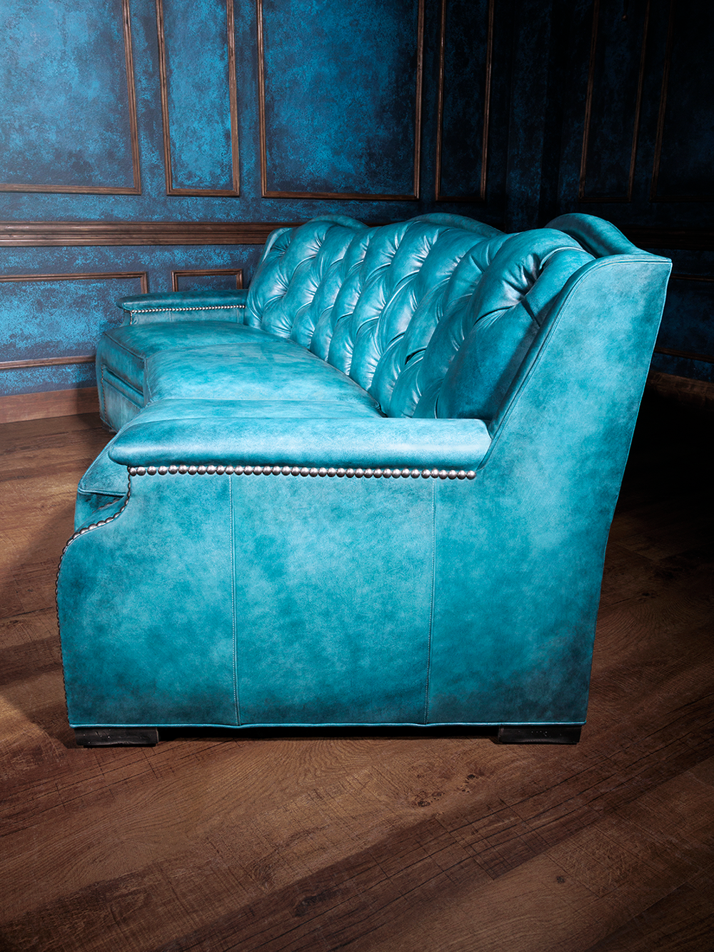 Sky Blue Tufted Leather Sofa in full-grain blue leather with silver nailhead accents, styled in a moody Western space.