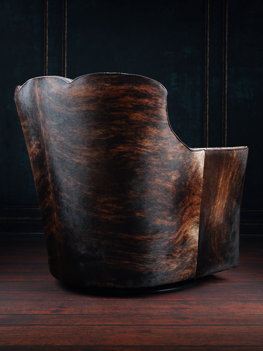 Tahoe Leather & Cowhide Swivel Chair with dark brown cowhide accents on outside back in a western space.