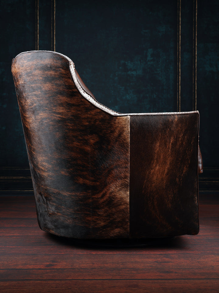 Tahoe Leather & Cowhide Swivel Chair with hair-on-hide accents on outside arm in a rustic space.