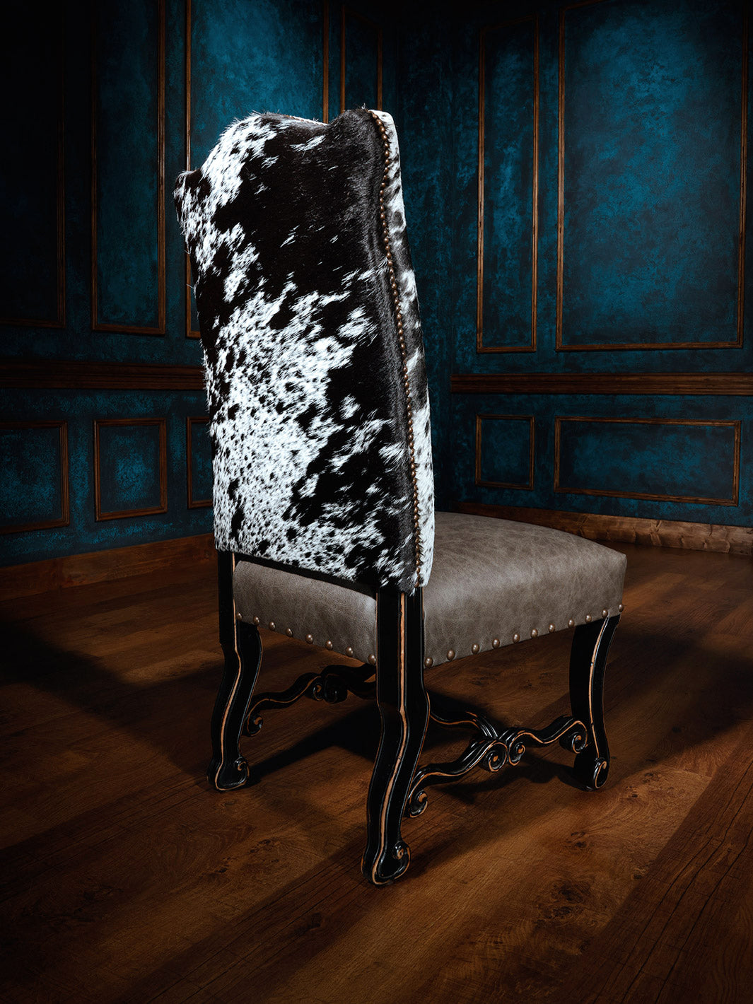 Texas Outlaw Western Dining Chair with speckled cowhide outside back and grey leather seat styled in a Western dining space.
