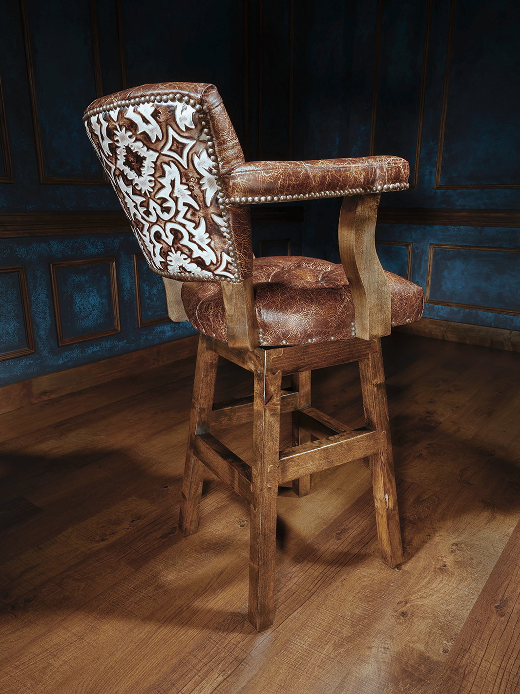 Texas Sunrise Chisum Western Bar Stool in full grain leather with embossed leather detailing in a rustic bar area.