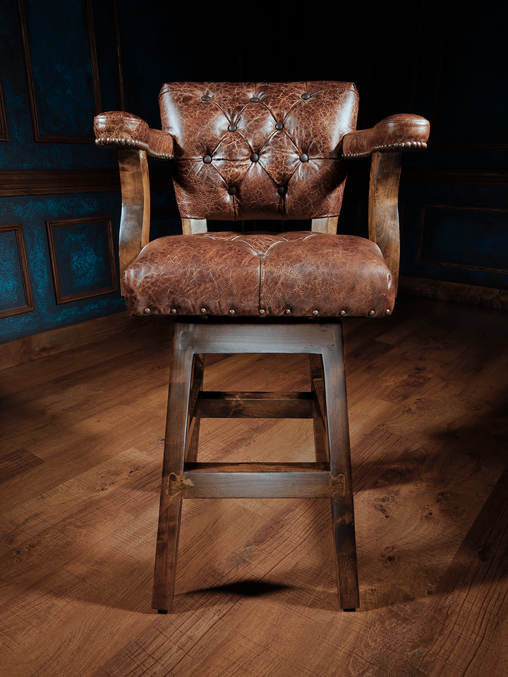 Texas Sunrise Chisum Western Bar Stool in top-grain leather with tufted seats and nailhead trim in a studio space.