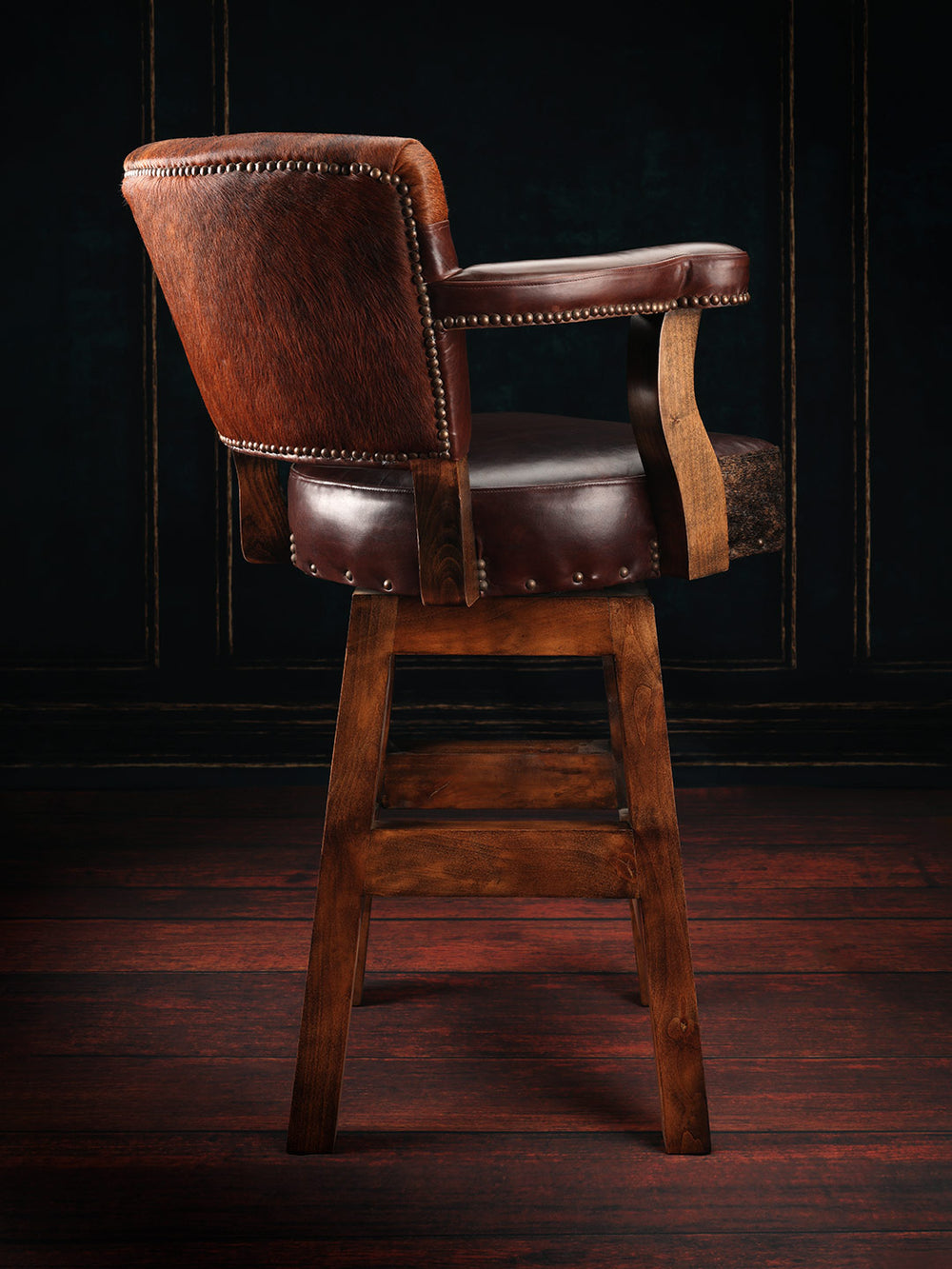 Western Cowhide Chisum Bar Stool in brown leather with cowhide accents in a rustic bar space.