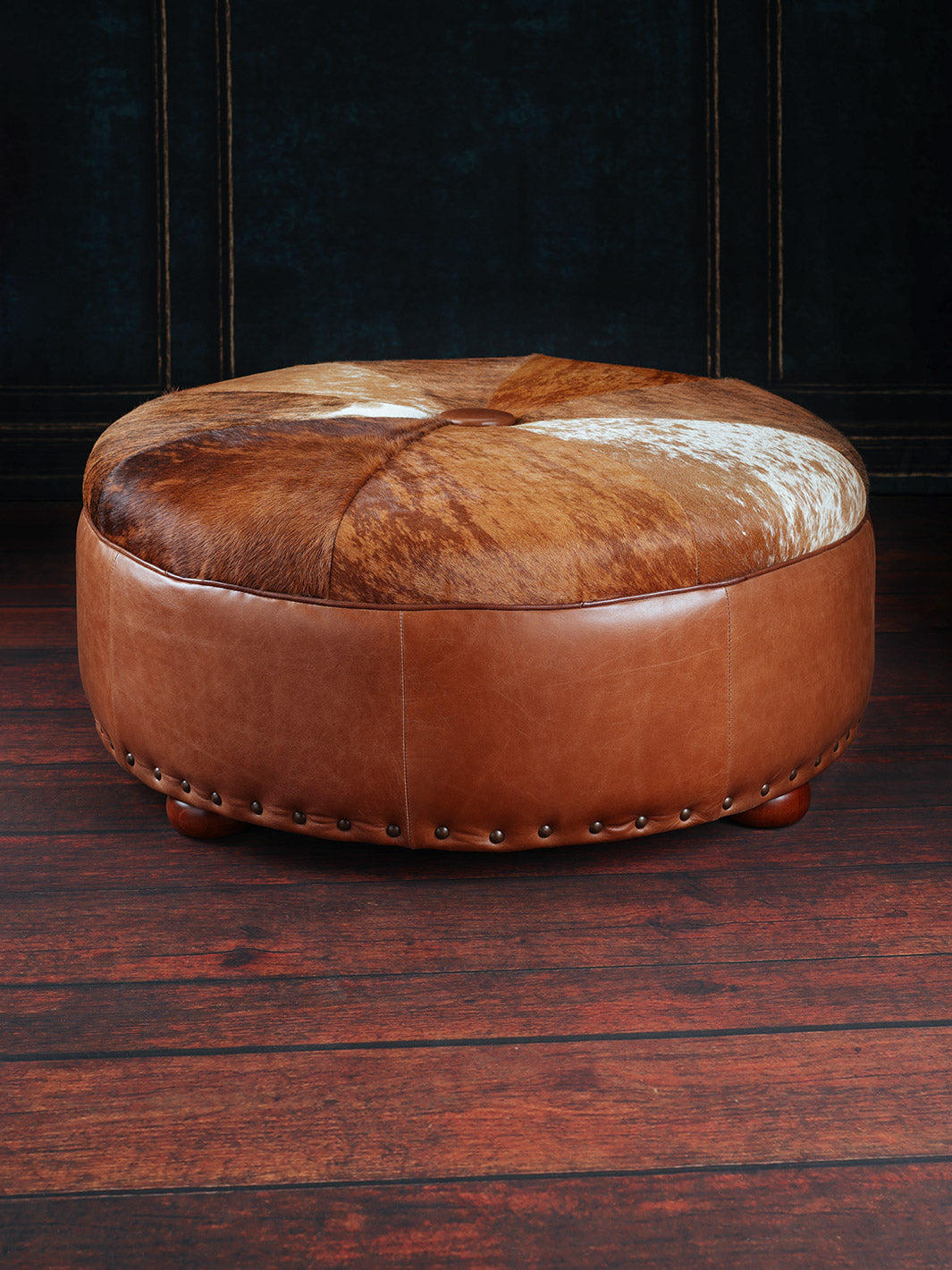 Western Sunset Cowhide Ottoman in top grain brown leather and brindle cowhide cushion in a western space.
