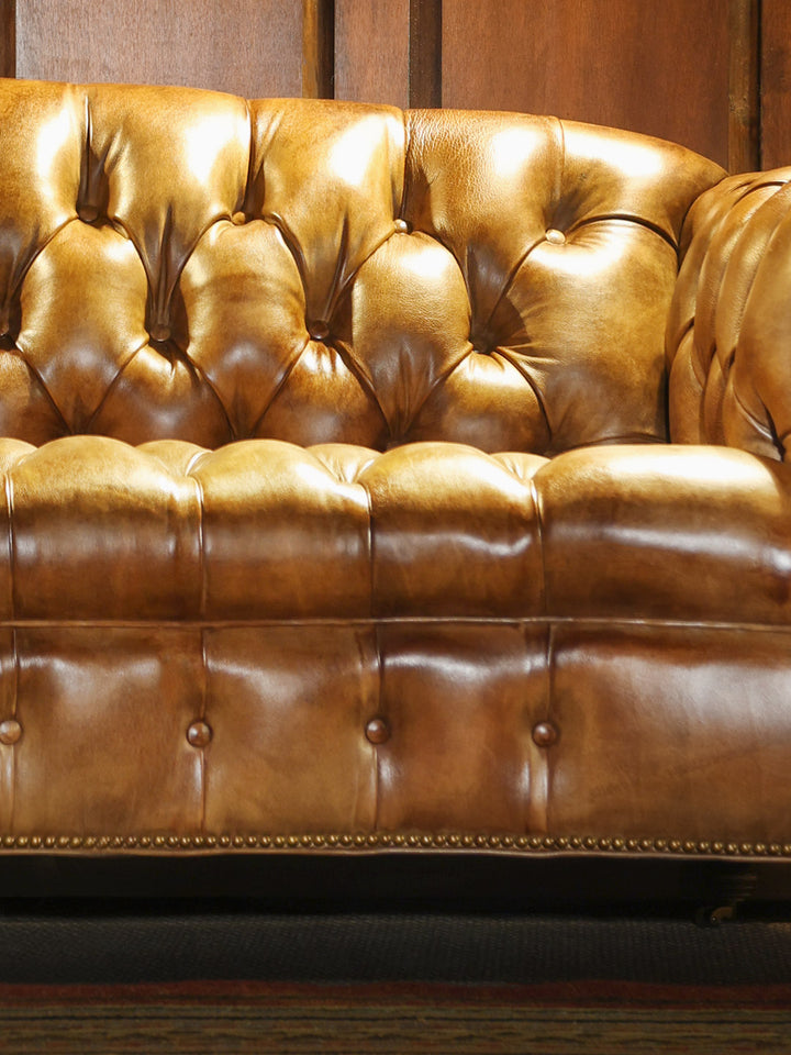 Weston Cane Chesterfield Leather Sofa in burnished brown leather with deep button tufting detailing in a close-up view.